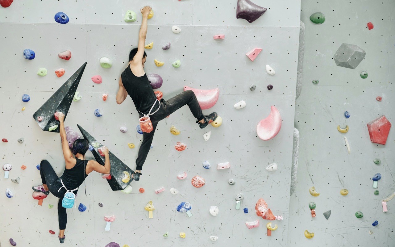 Two people climbing a wall