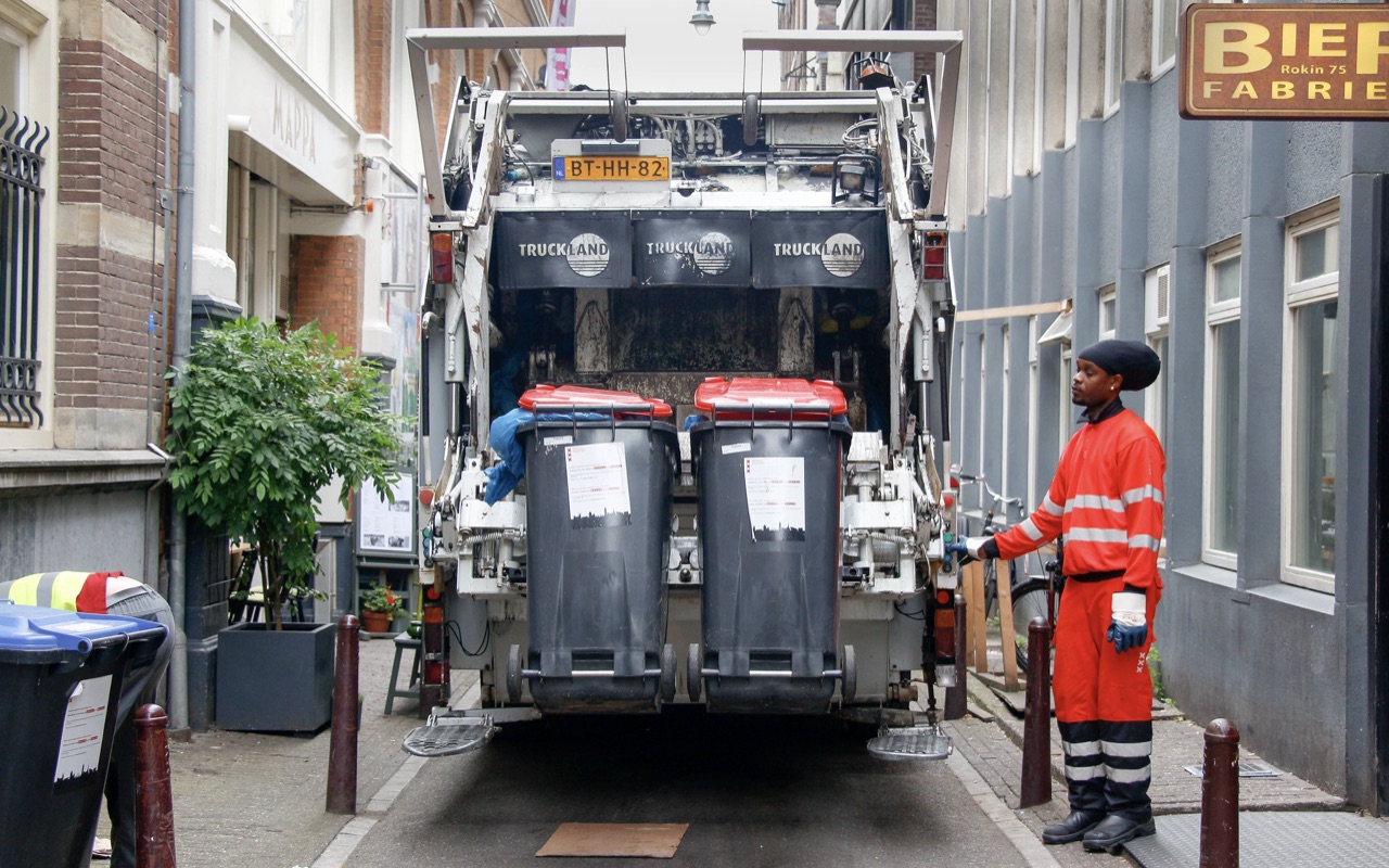 A worker operating a garbage truck in Amsterdam