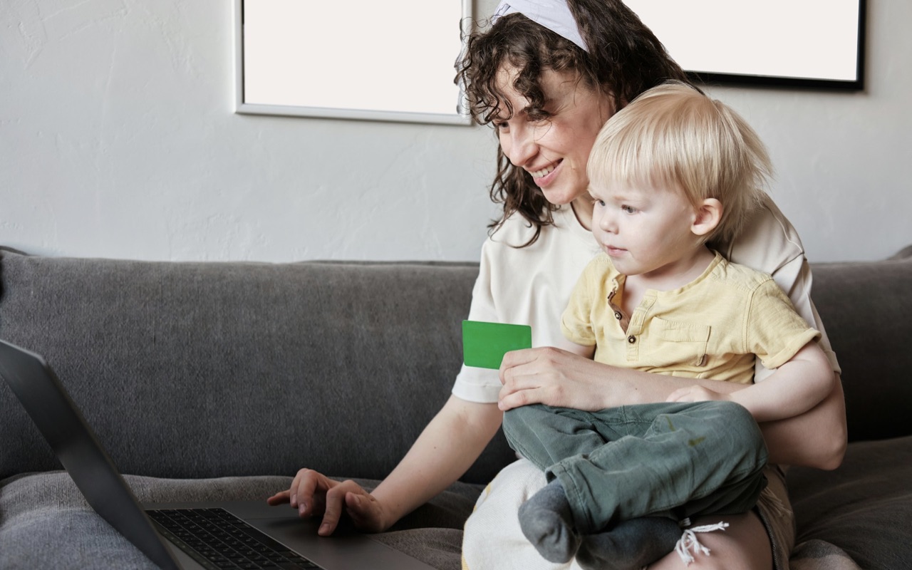 A mother with baby on lap making an online purchase